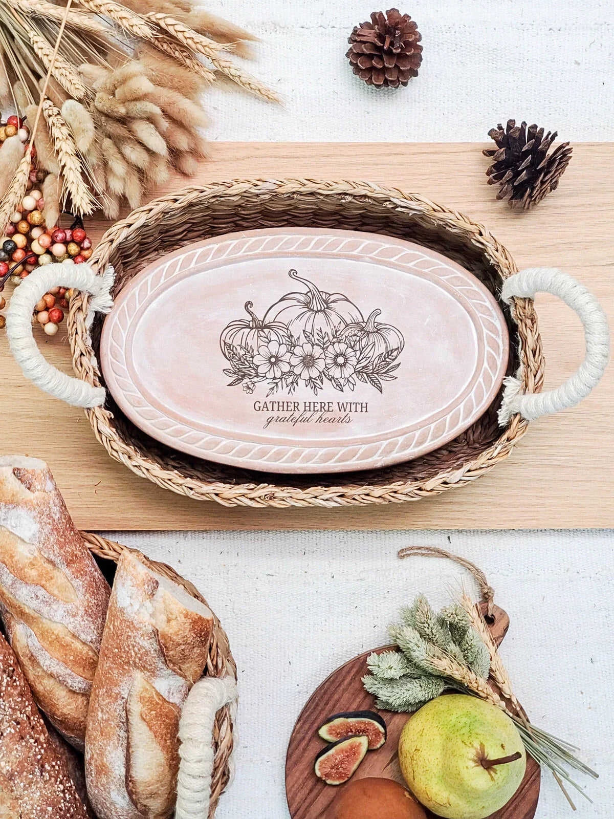 Rustic autumn tray with pumpkin floral design and text, surrounded by bread, pears, figs, and pinecones