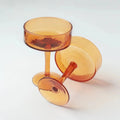 Amber glass coupe cocktail glasses on white background, modern drinkware by Qu!rk Boutique
