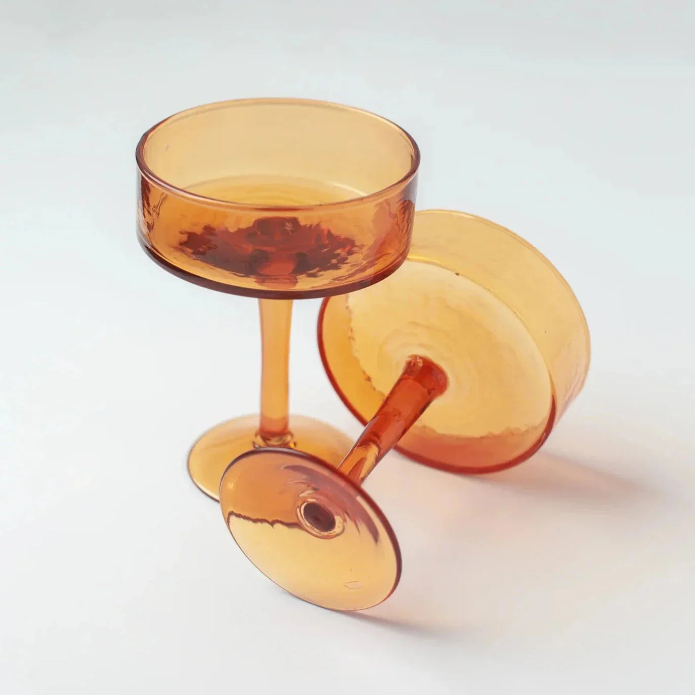 Amber glass coupe cocktail glasses on white background, modern drinkware by Qu!rk Boutique