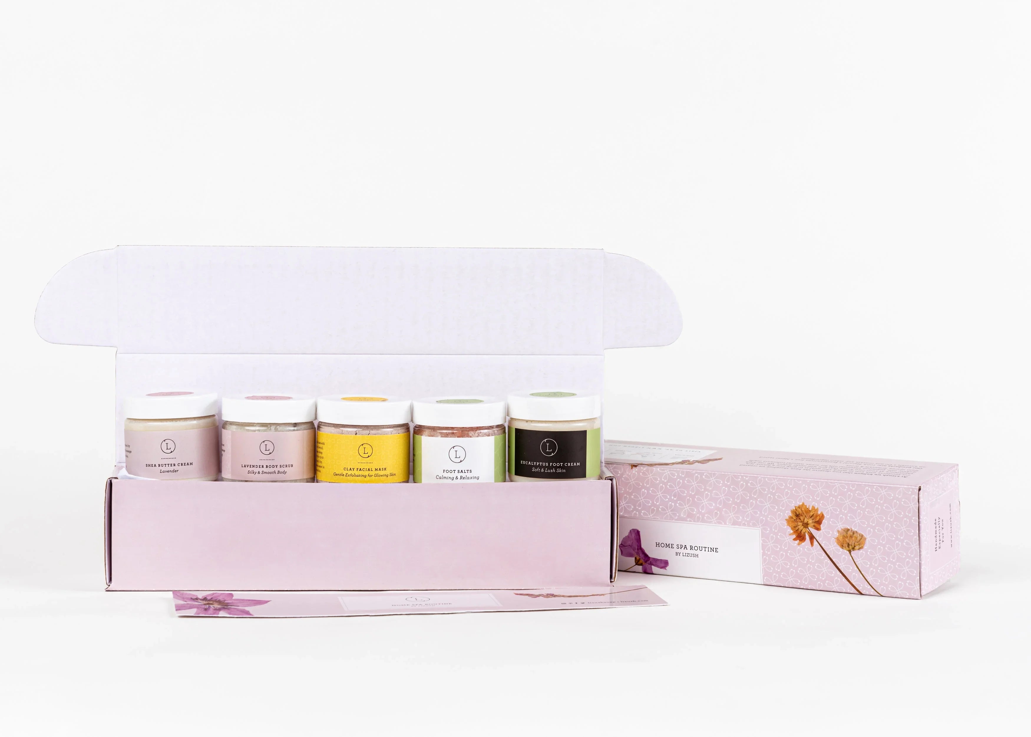 Home spa routine gift set with five small jars of skincare products in pastel pink box