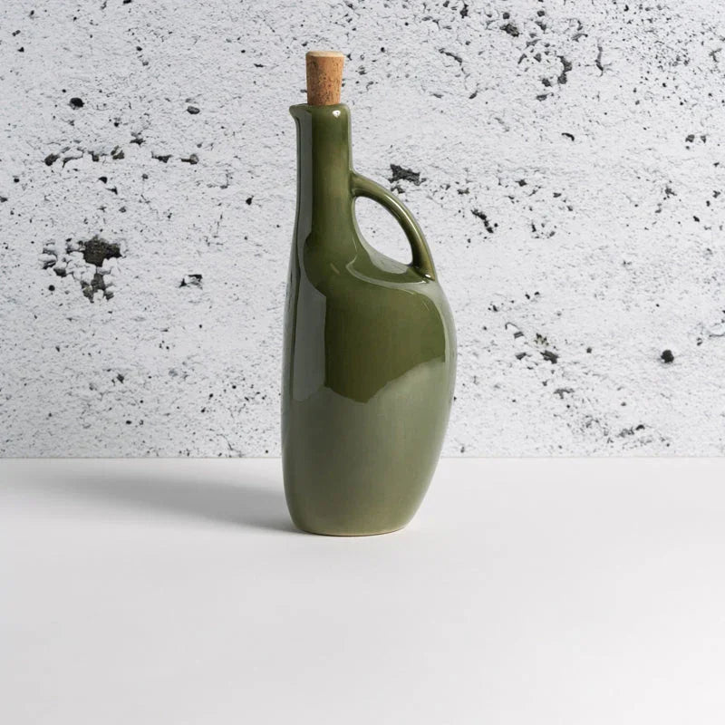 Glossy green ceramic bottle with cork, modern handle, on white surface at Qu!rk Boutique