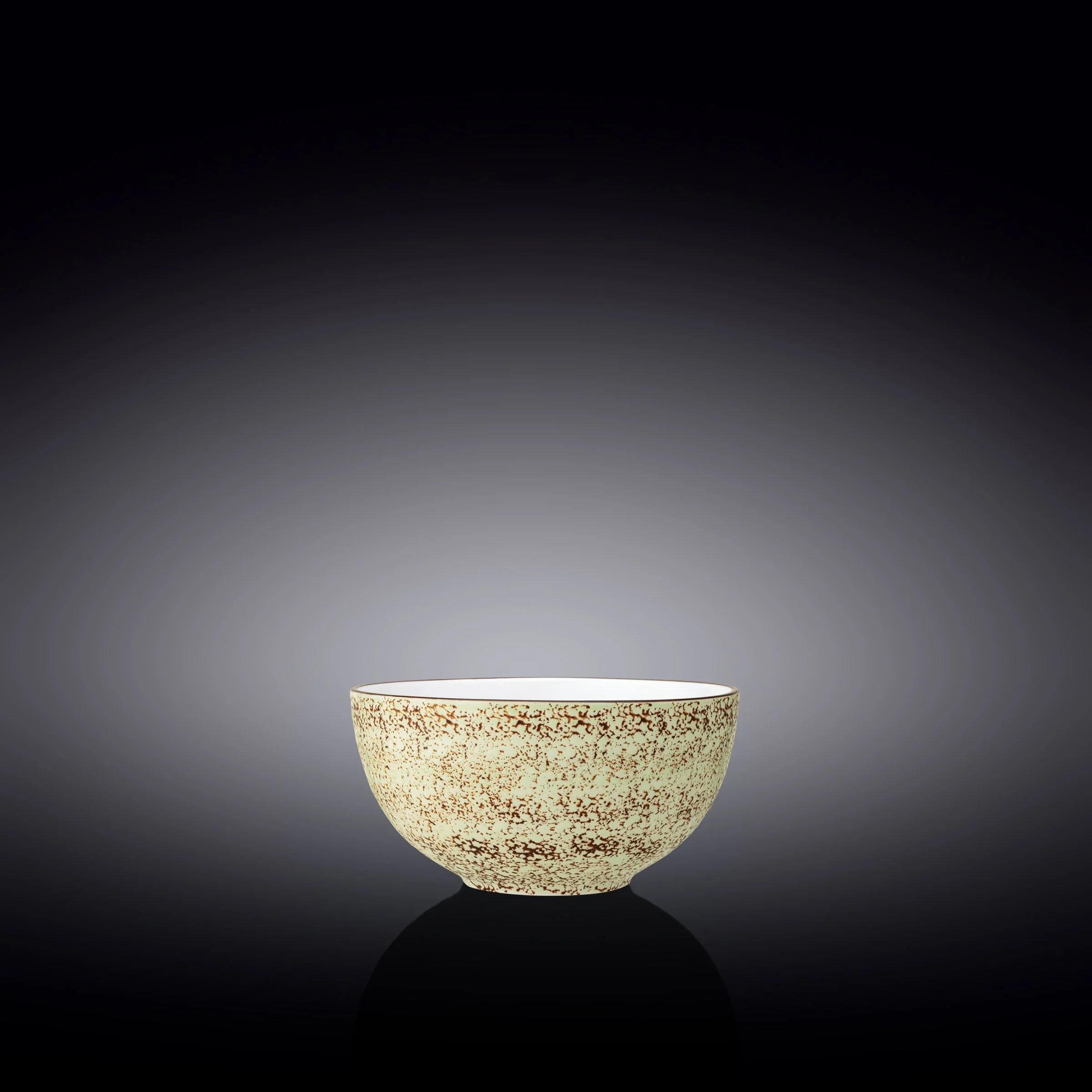 Speckled cream ceramic bowl with brown pattern on black gradient background, artist-designed gift