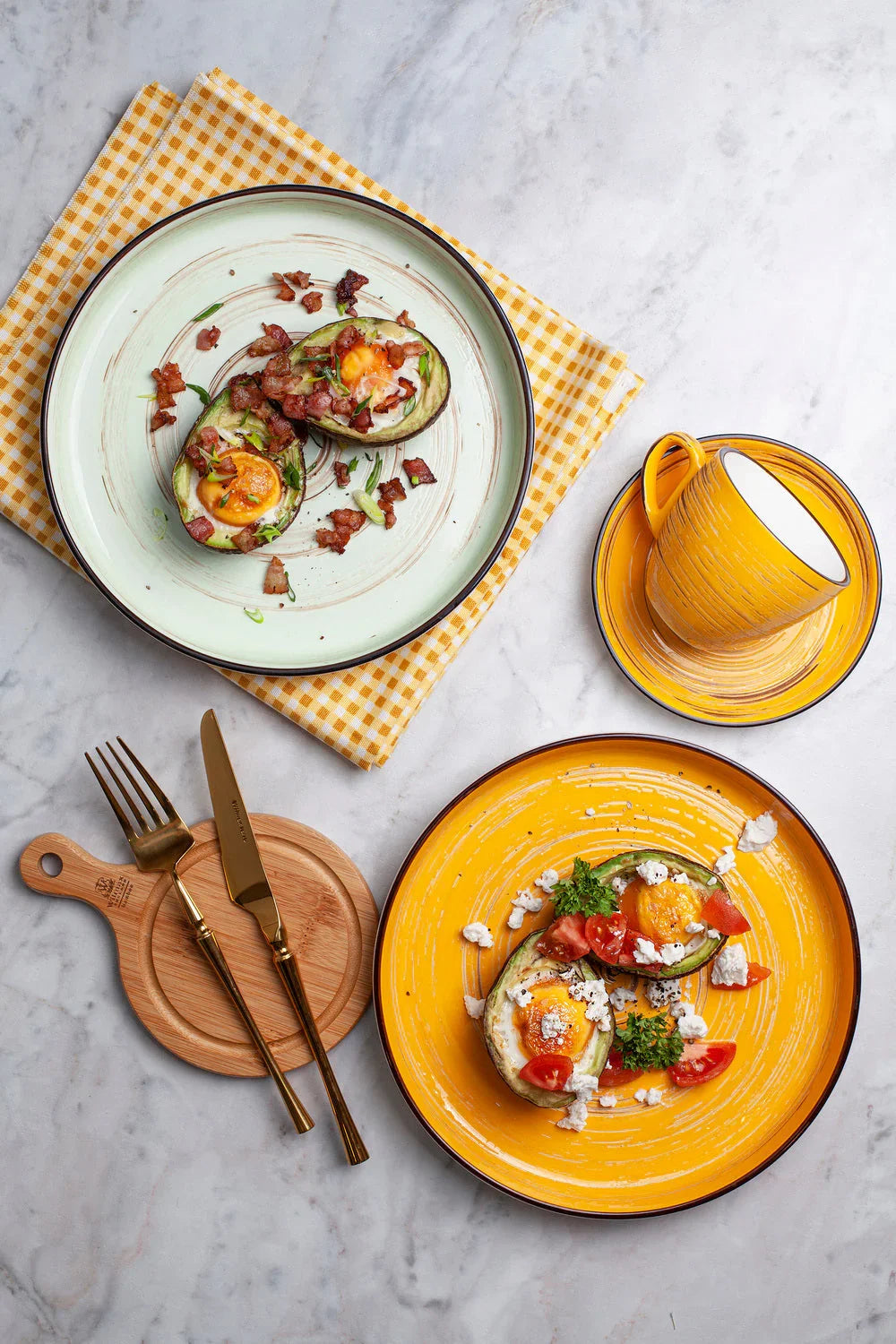 Colorful ceramic plates and cups with avocado egg breakfast, on marble at Qu!rk Boutique & Gift Shop