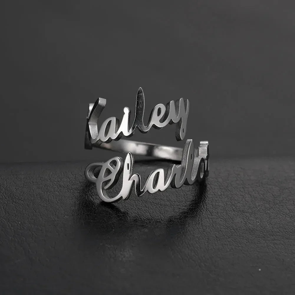 Silver custom name ring with names Kailey and Charla on dark textured background