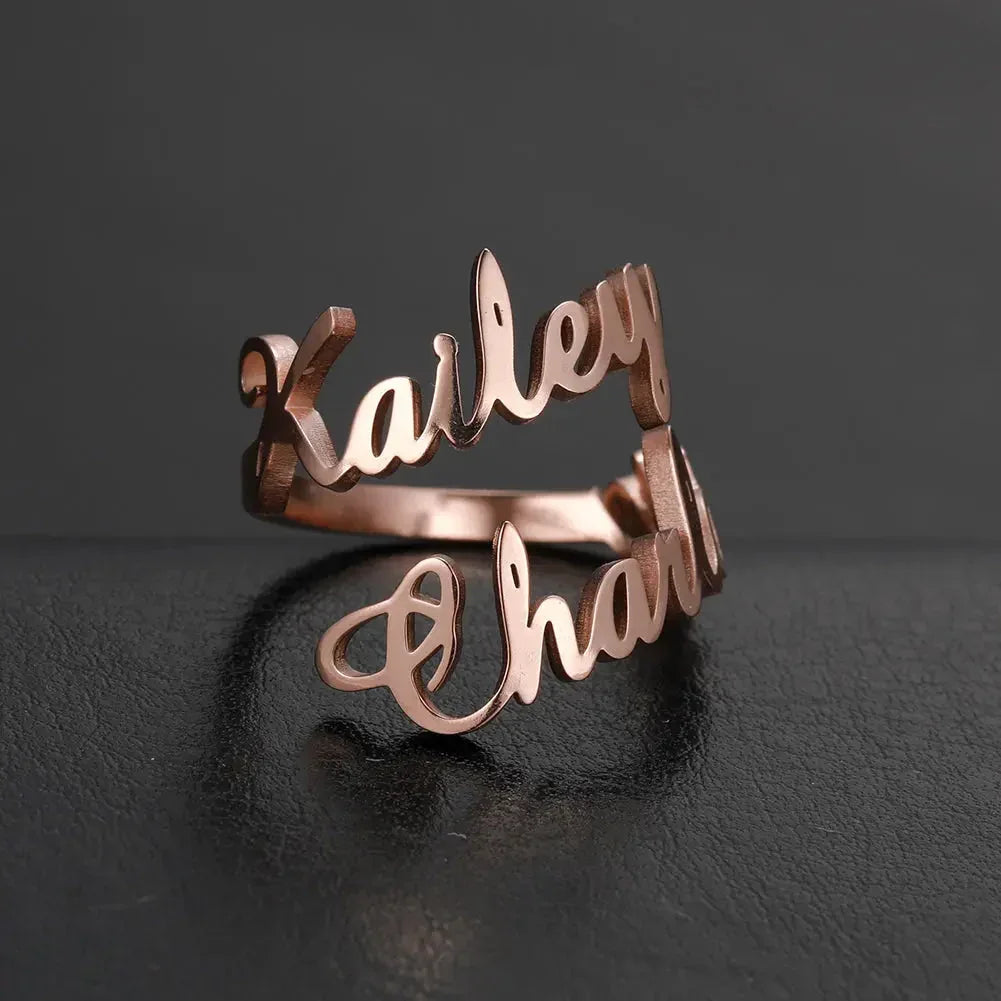 Rose gold personalized name ring with Kailey and Chanty on black leather surface
