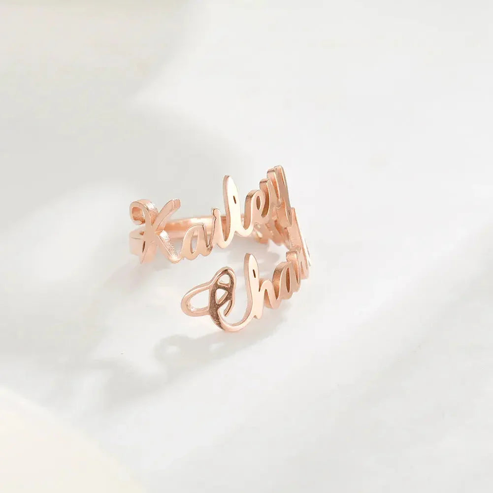Rose gold custom name ring with cursive script on white surface