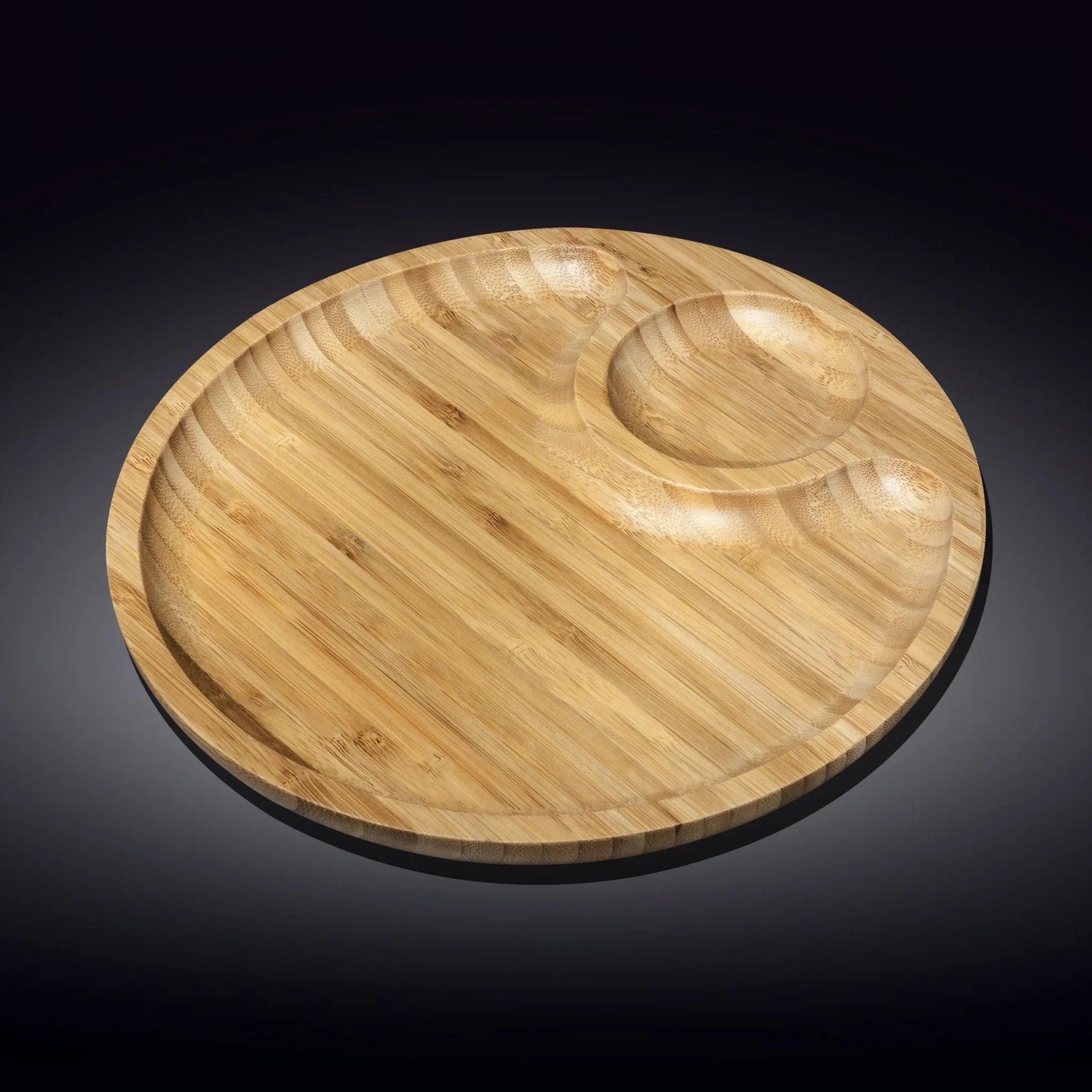 Round bamboo serving platter with multiple compartments on black background