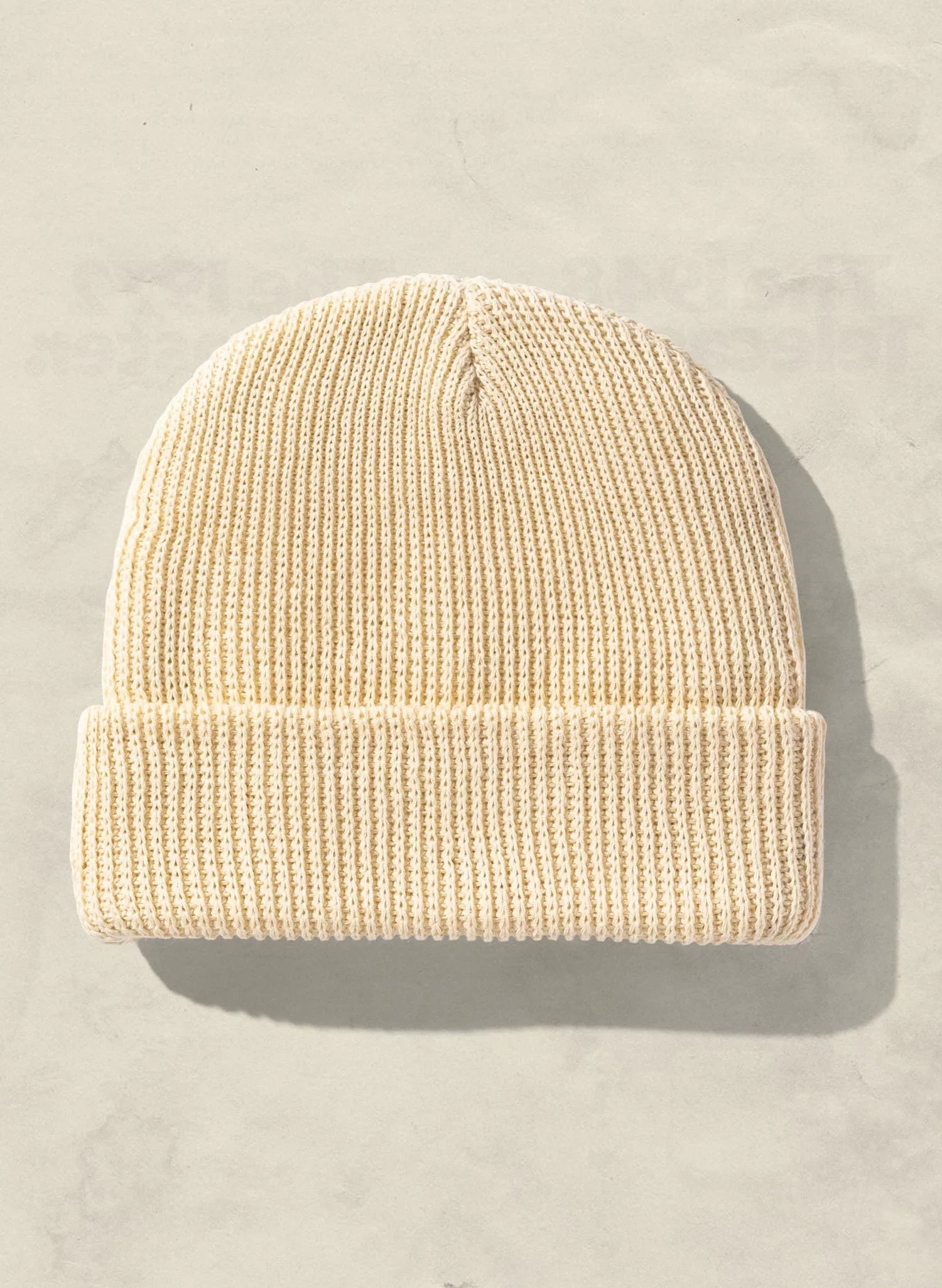 Cream ribbed knit beanie from Qu!rk Boutique, minimalist winter accessory on light background