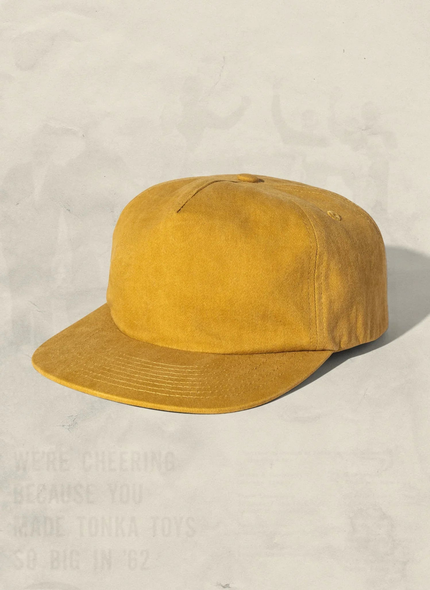 Mustard yellow canvas baseball cap on neutral background, artist-designed sustainable fashion