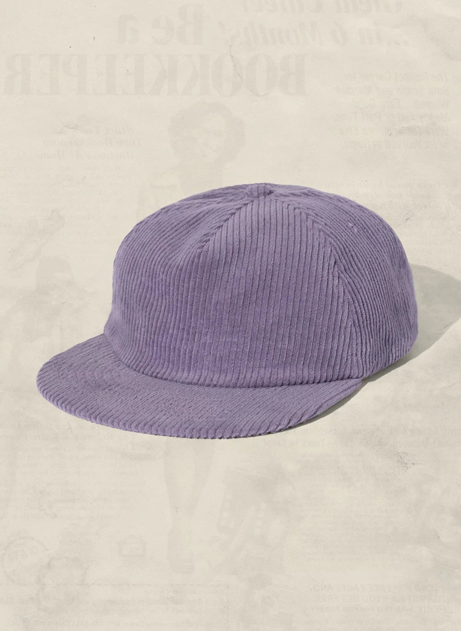 Lilac corduroy cap with flat brim on neutral background, artist-designed Qu!rk Boutique accessory