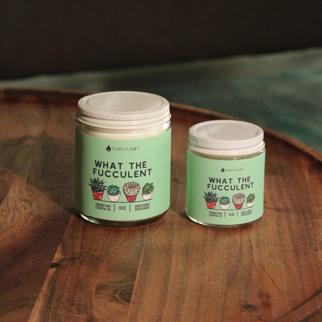Two green labeled candles with succulent illustrations on wooden tray, coconut wax essential oil candles