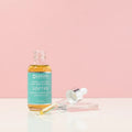 Laguna Herbals Soften herbal bath and body oil bottle with dropper, on pink background