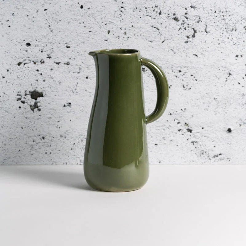 Olive green ceramic pitcher with handle on white table, minimalist modern decor at Qu!rk Boutique