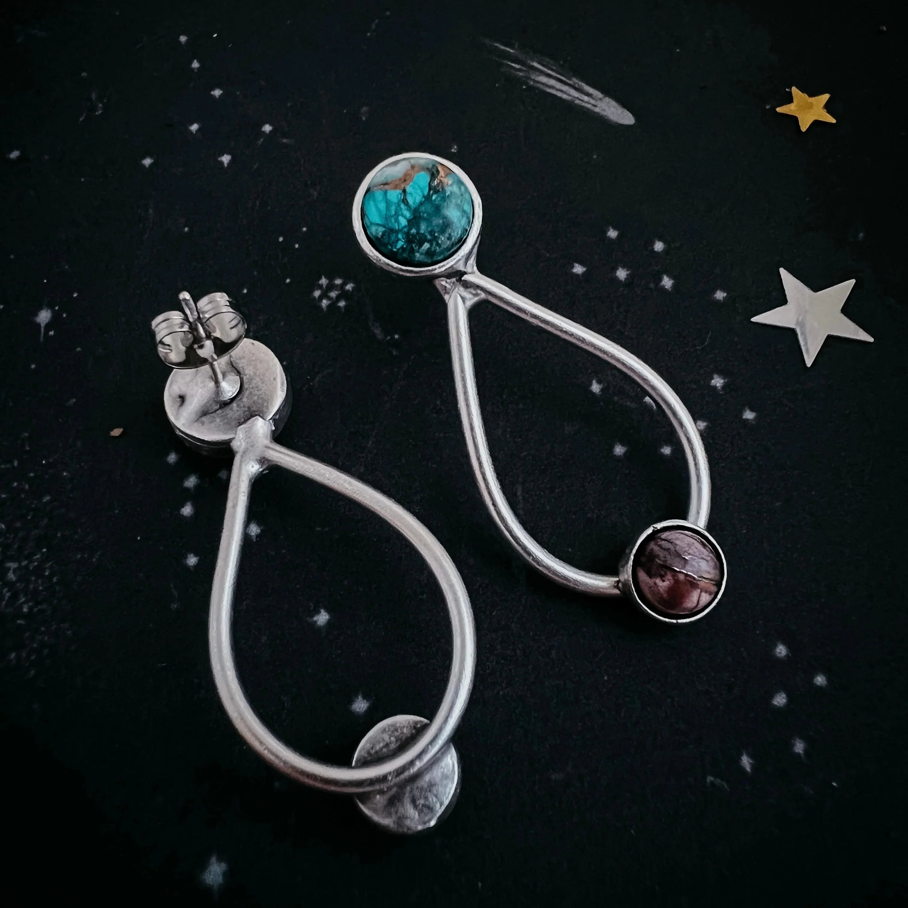 Handmade silver earrings with turquoise and purple stones on celestial black background, Qu!rk Boutique.