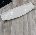 Modern white ceramic platter on rustic wood table at Qu!rk Boutique