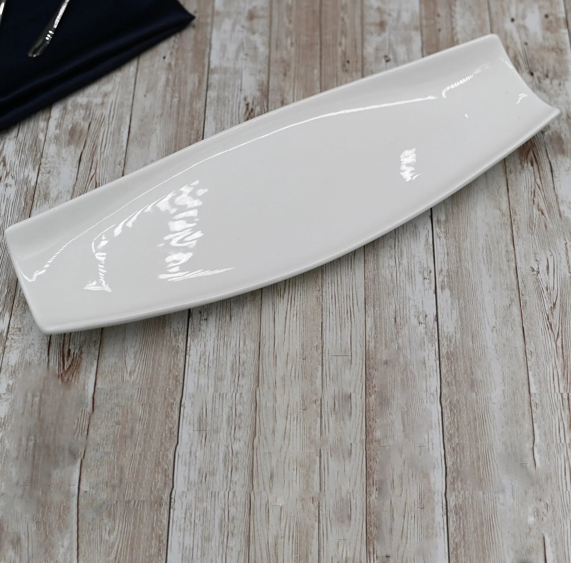 Modern white ceramic platter on rustic wood table at Qu!rk Boutique