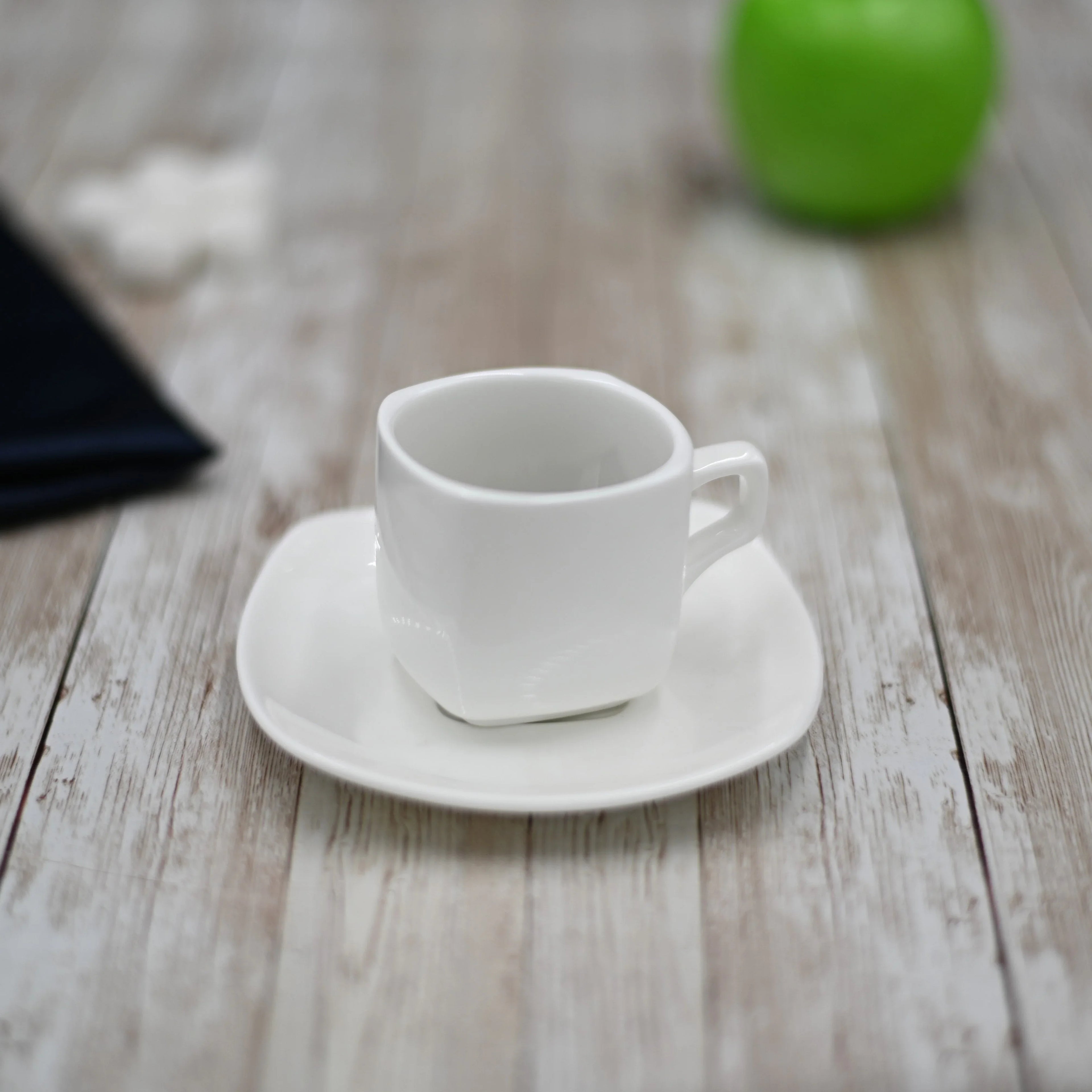 Modern white ceramic cup and saucer on rustic wood table, Qu!rk Boutique artistic kitchenware