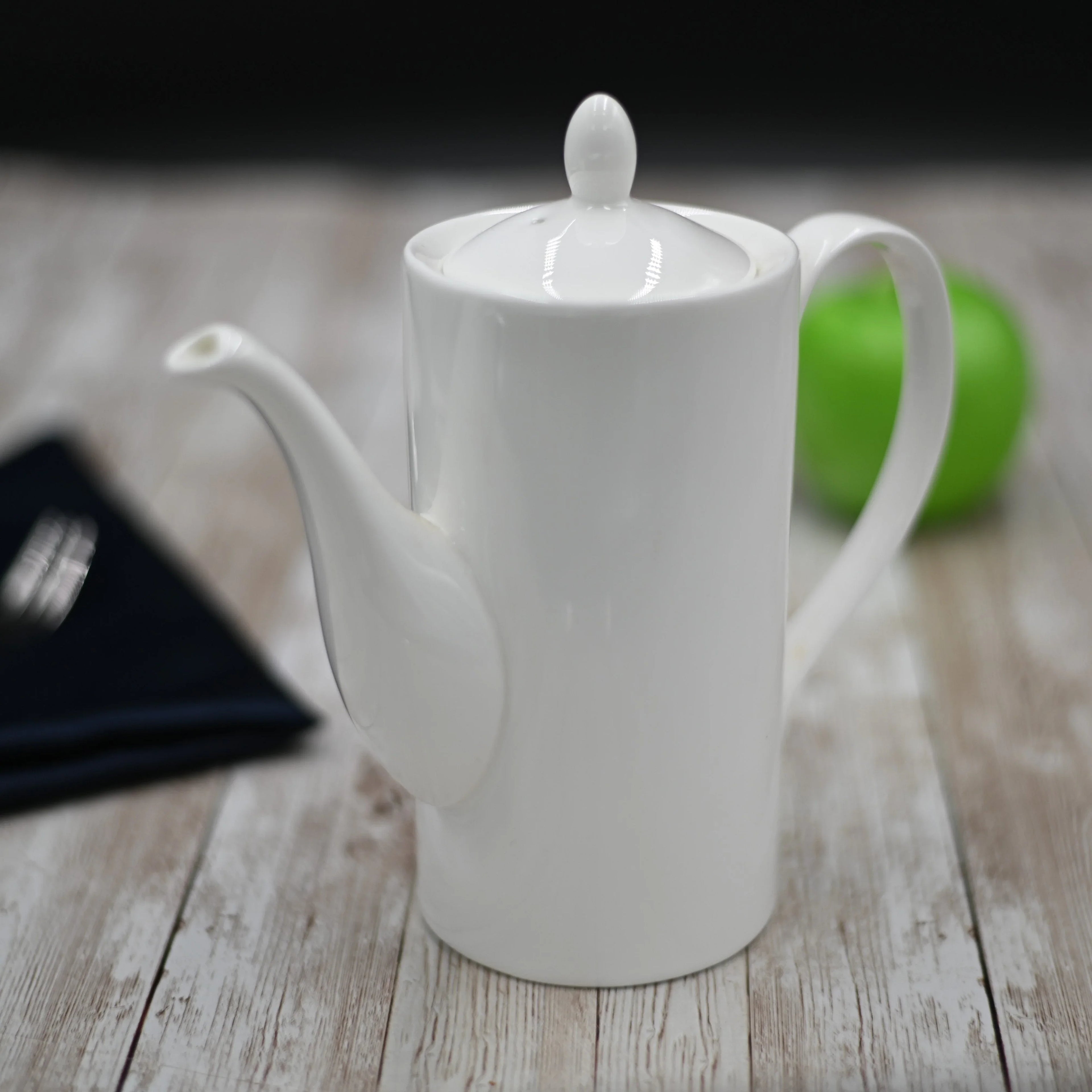 White ceramic teapot on rustic wood table, modern home decor at Qu!rk Boutique