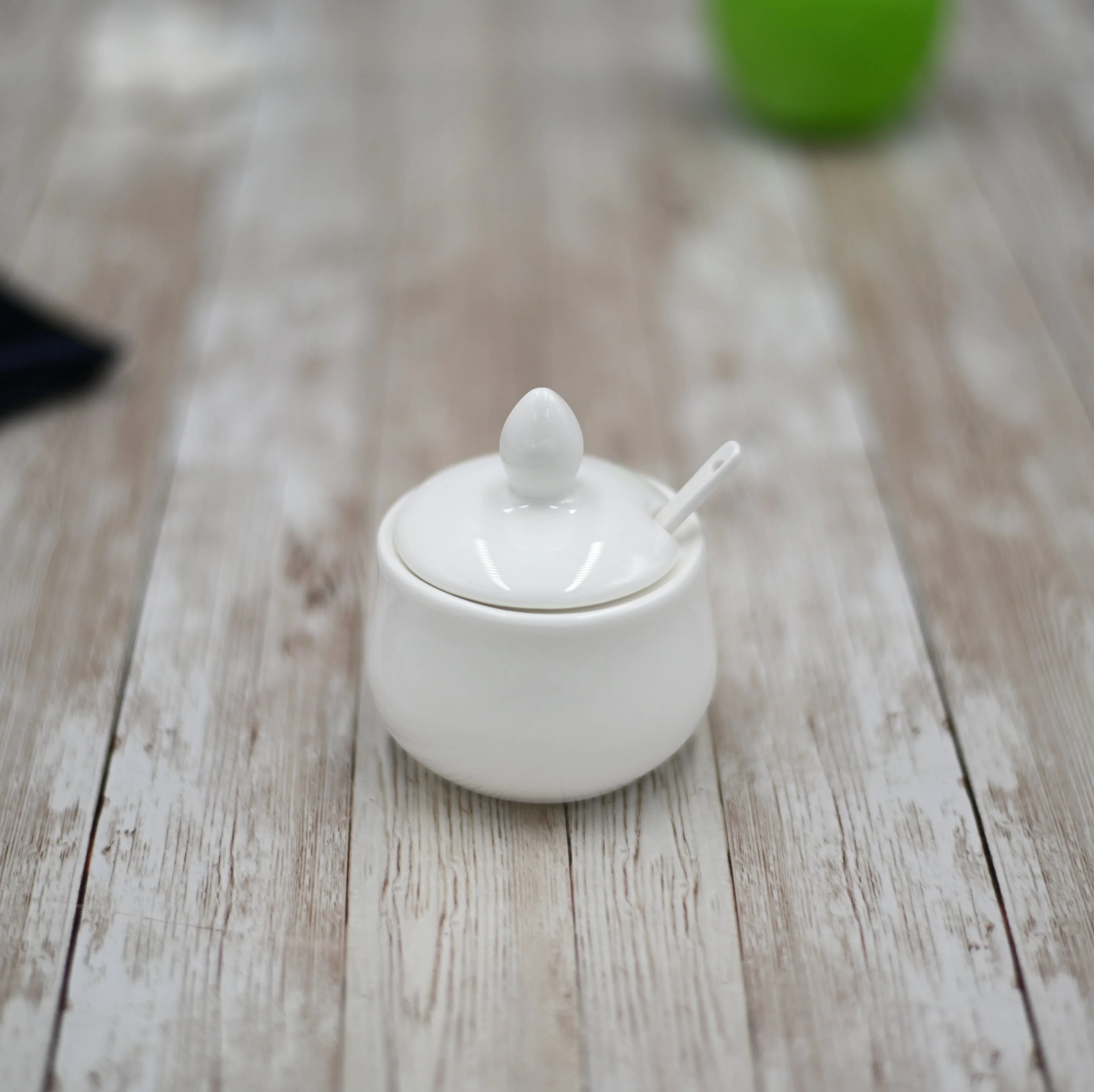 White ceramic sugar bowl with lid and spoon on rustic wooden table, Qu!rk Boutique style