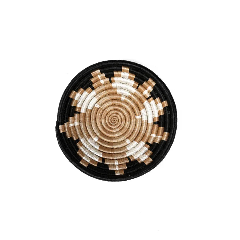 Handwoven decorative bowl with black, beige, and white spiral pattern on white background