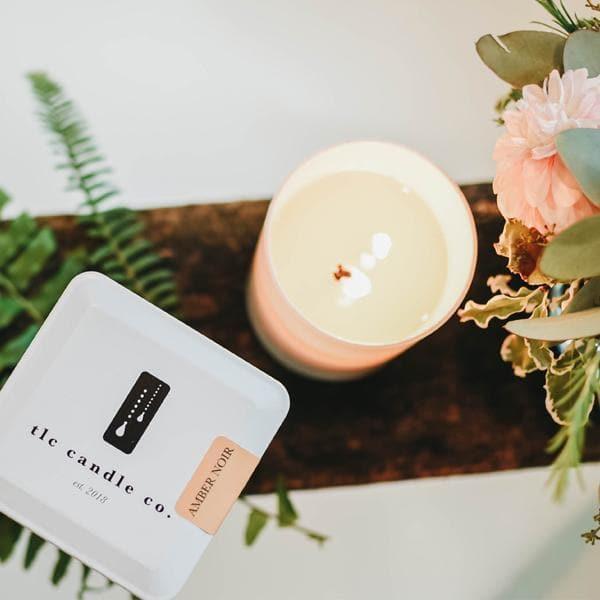 Amber Noir candle in white jar with floral decor at Qu!rk Boutique & Gift Shop