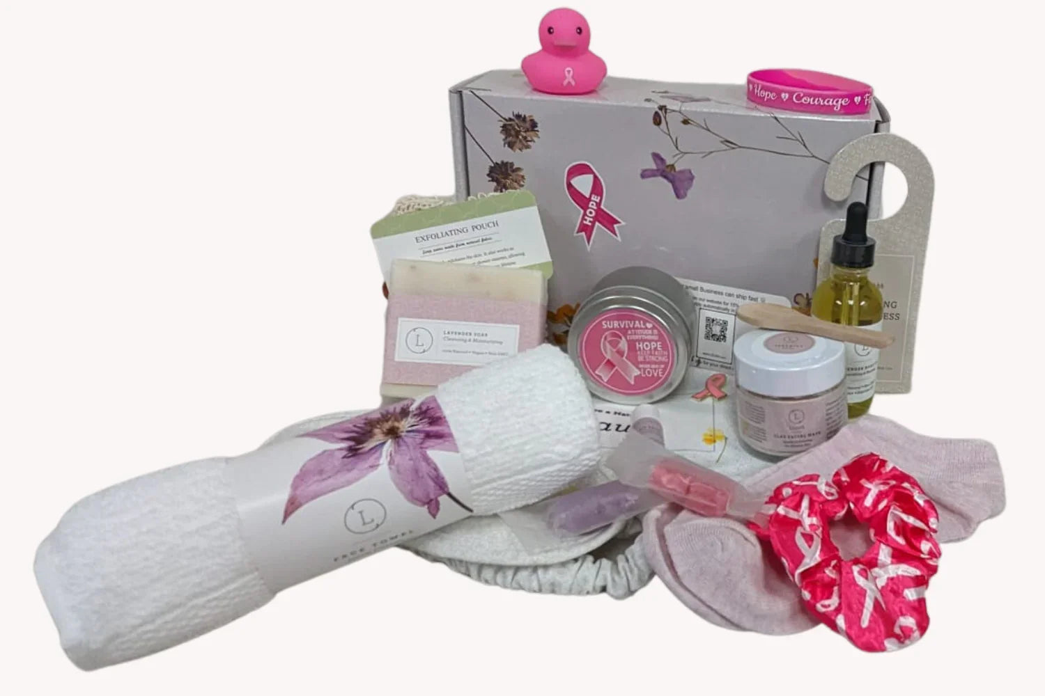 Breast cancer awareness self-care kit with pink ribbon items, exfoliating pouch, socks, oil, and pink rubber duck