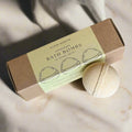 Slow North lemongrass bath bombs set with natural packaging and one round bath bomb on marble surface
