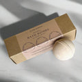 Slow North Patchouli bath bombs set with brown packaging and one bath bomb on marble surface