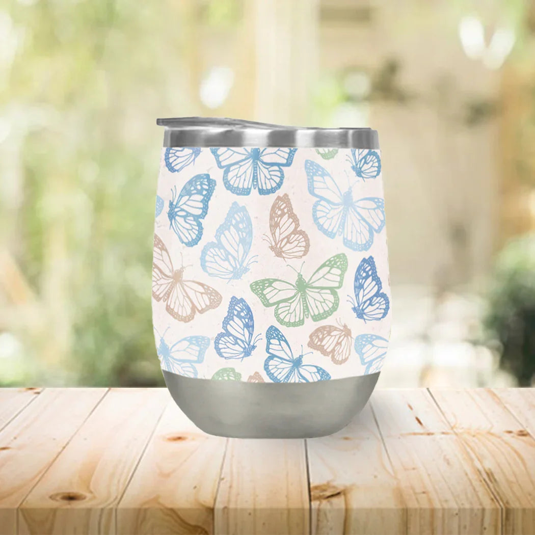 Stainless steel wine tumbler with blue and green butterfly pattern on wood table, Qu!rk Boutique