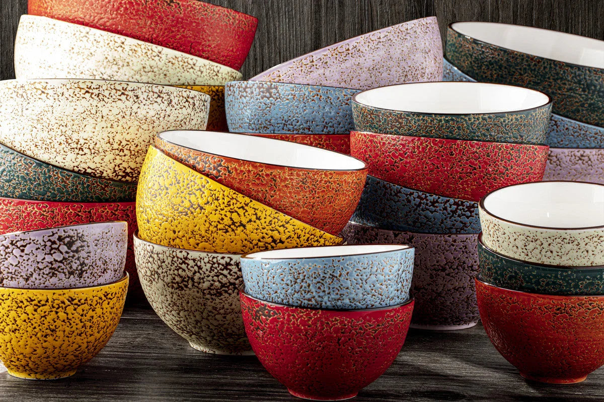 Colorful artist-designed speckled ceramic bowls stacked on dark wood, Qu!rk Boutique gifts