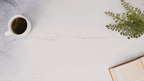 Bridesmaid gift box with self-care products, greenery, book, and coffee on a light tabletop