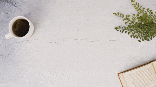 Bridesmaid gift box with self-care products, greenery, book, and coffee on a light tabletop