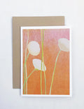 White flowers with green stems on orange textured background greeting card with kraft envelope