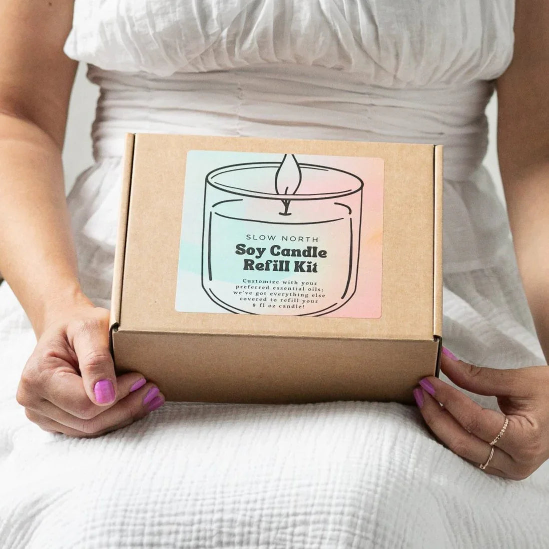 Woman holding Slow North DIY Soy Candle Refill Kit box with pastel label, eco-friendly gift