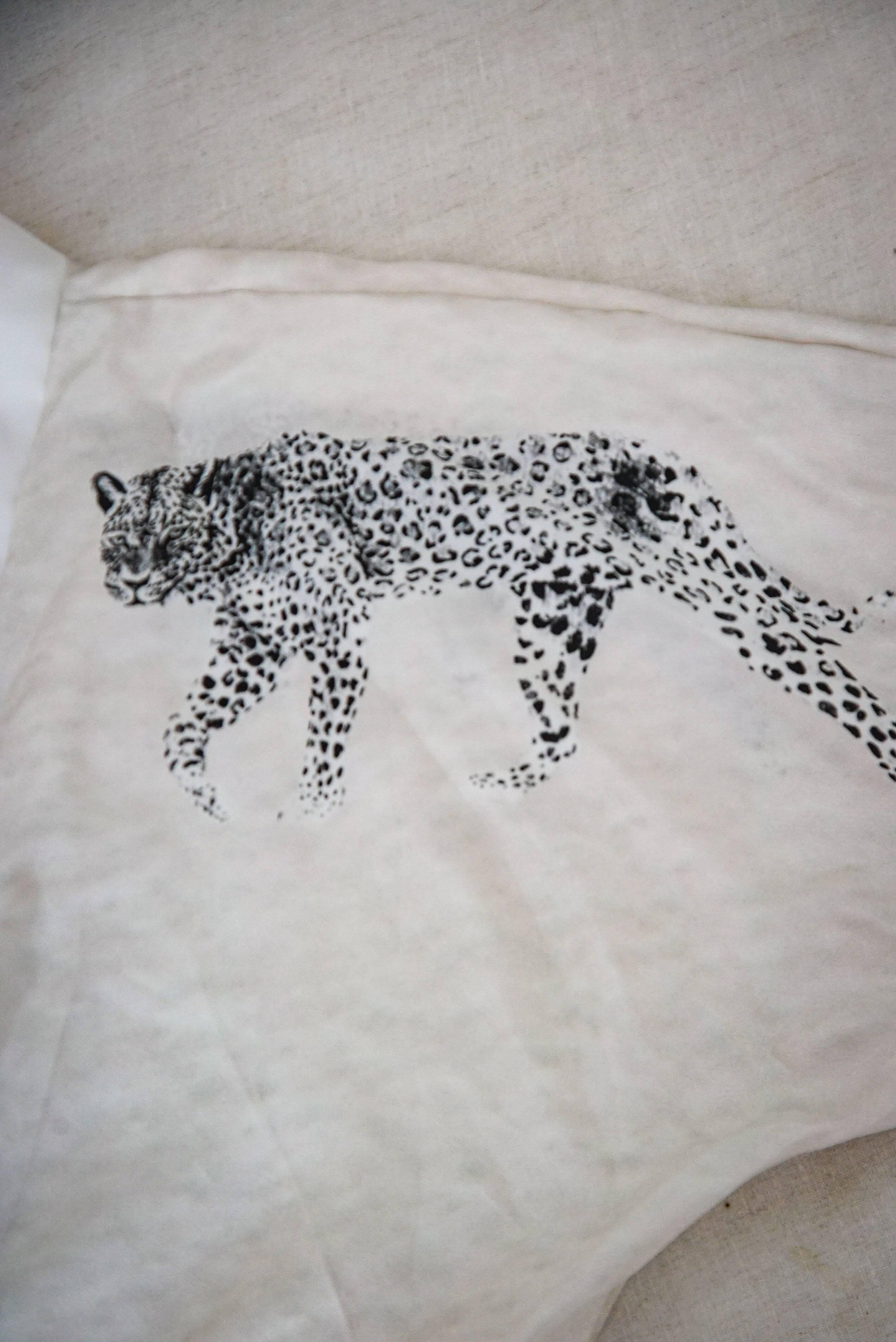 White fabric with black and white leopard print design laid on beige surface