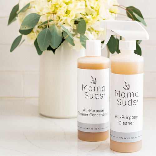 Mama Suds all-purpose cleaner bottles on counter with flowers, eco-friendly boutique product