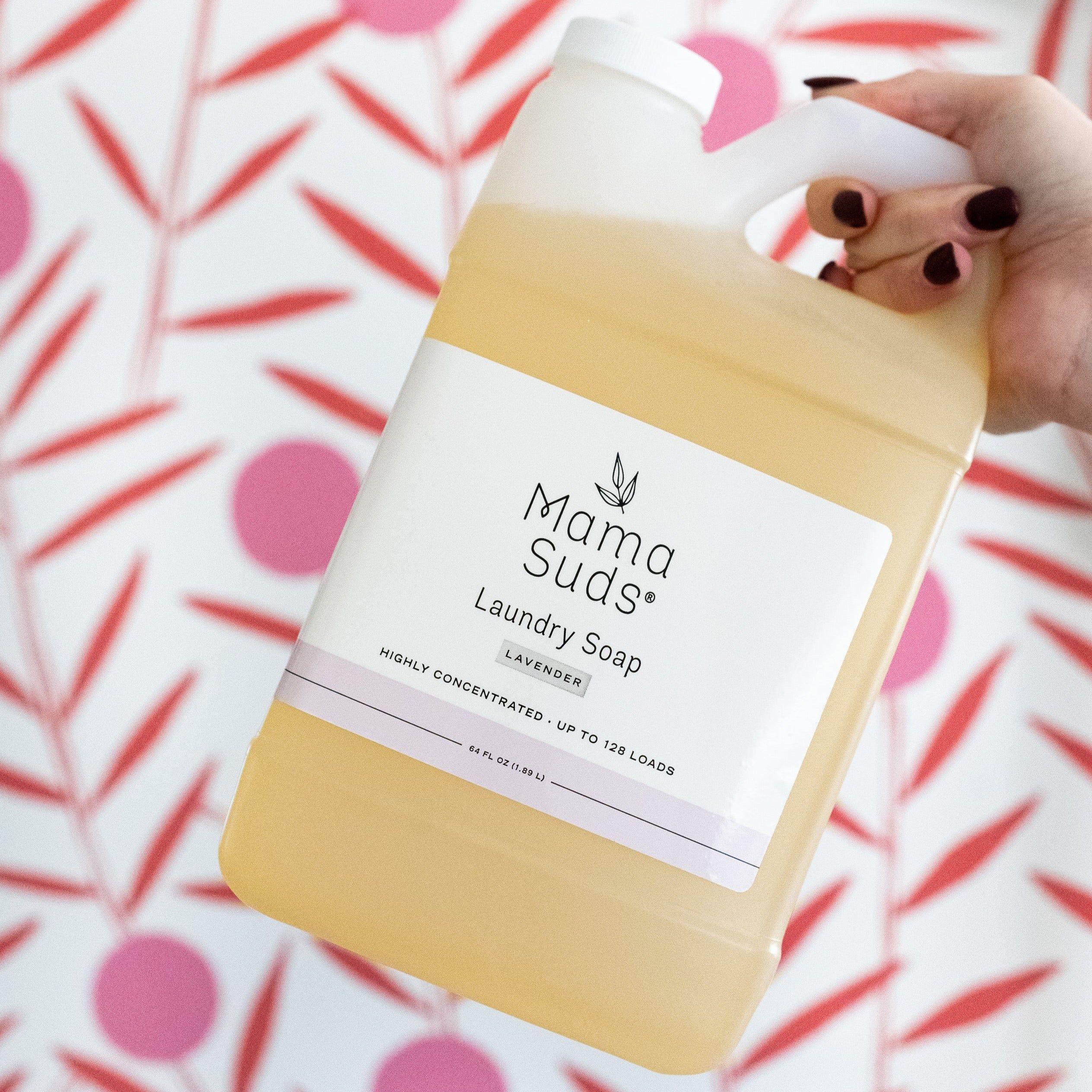 Hand holding Mama Suds lavender laundry soap jug, eco-friendly cleaner at Qu!rk Boutique