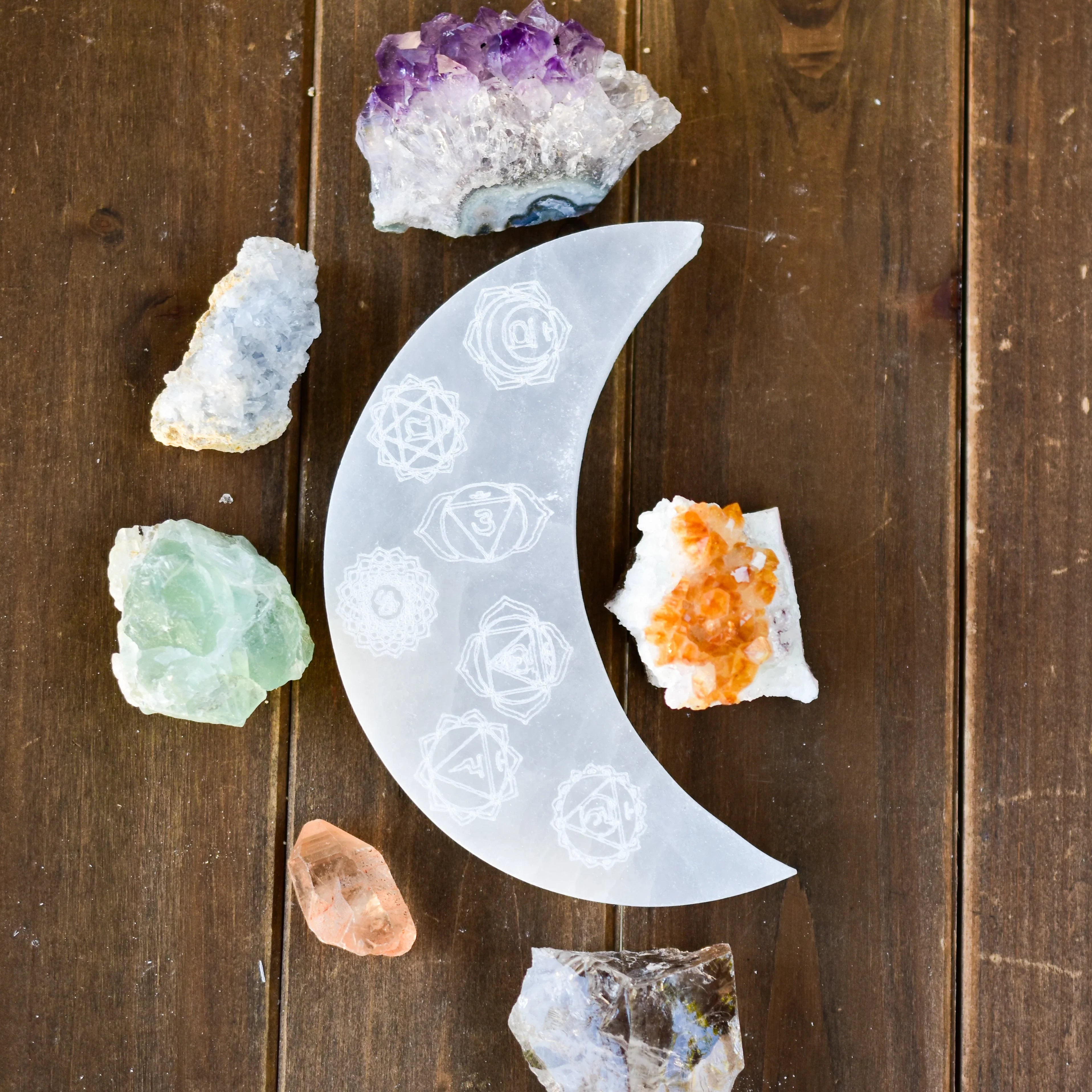 Crystal collection with engraved crescent moon on wood table, Qu!rk Boutique cosmic gifts