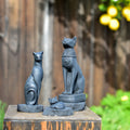 Artist-designed black cat figurines with Egyptian style, displayed outdoors at Qu!rk Boutique