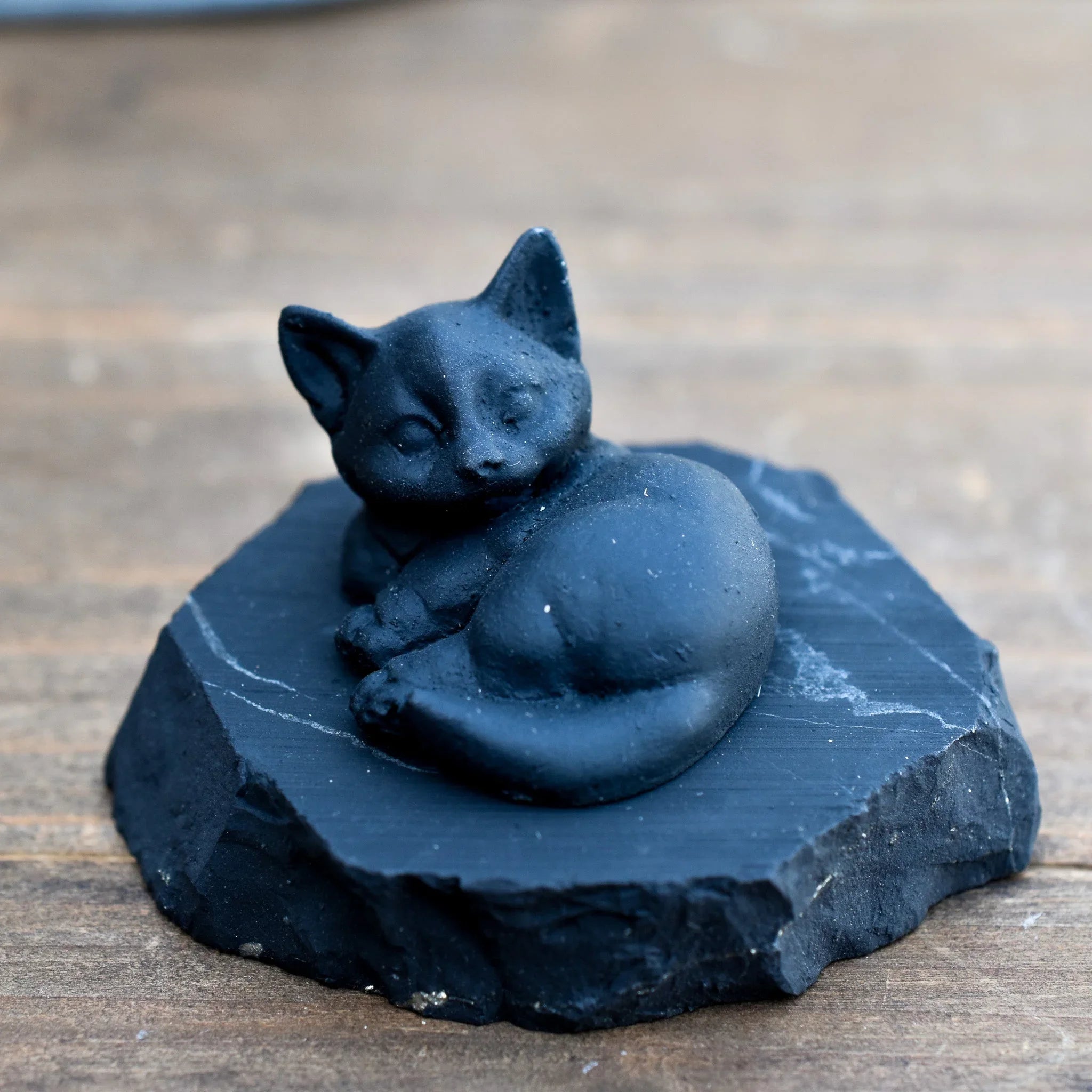 Black cat sculpture on stone slab, artisan gift at Qu!rk Boutique
