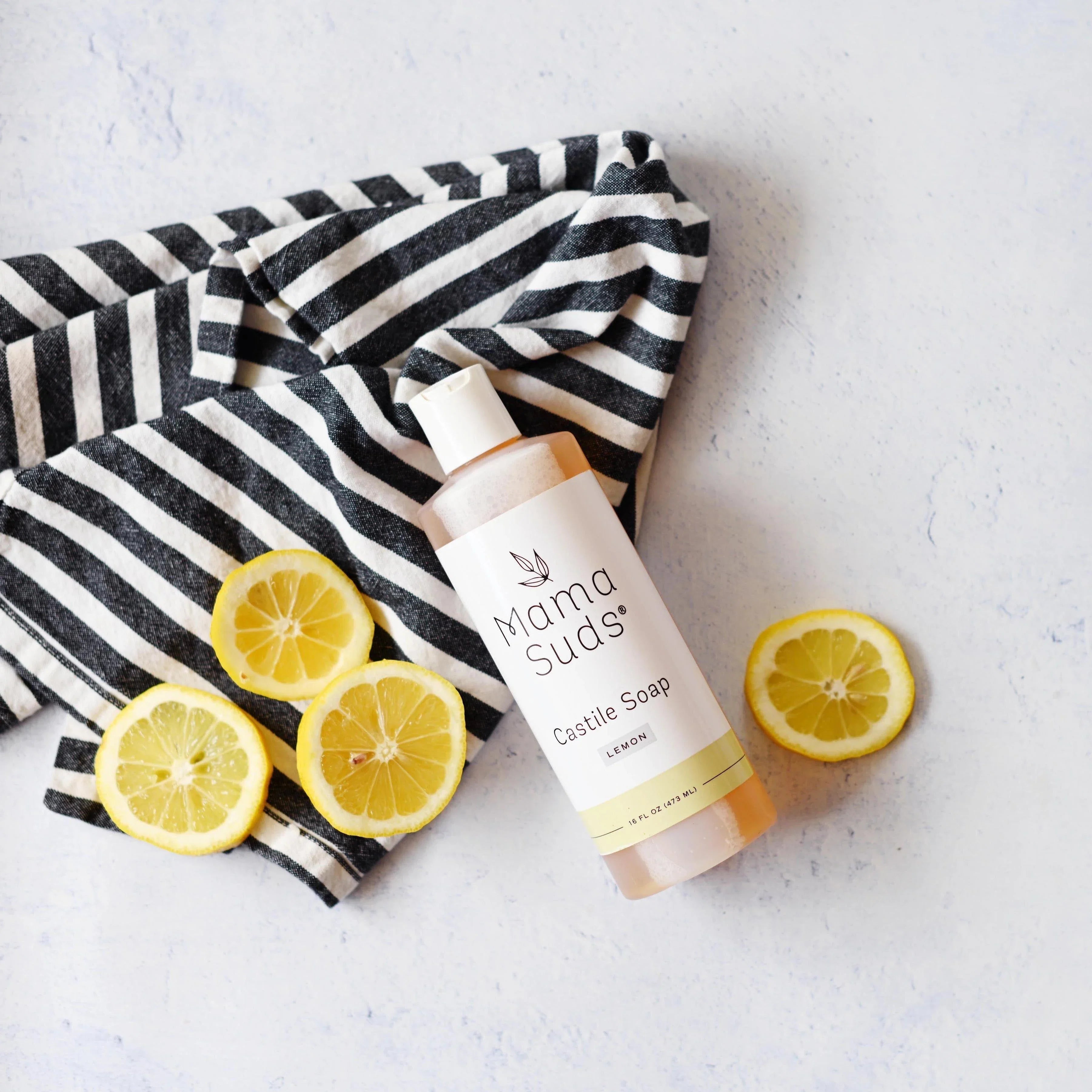 Mama Suds Lemon Castile Soap bottle with sliced lemons and striped towel, eco-friendly gift idea