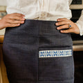 Woman in white blouse wearing artisan denim skirt with blue embroidered pocket, Qu!rk Boutique
