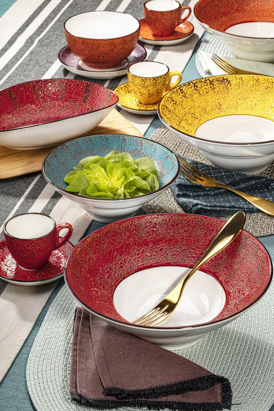 Colorful artist-designed deep plates, bowls, and cups on a modern table setting at Qu!rk Boutique