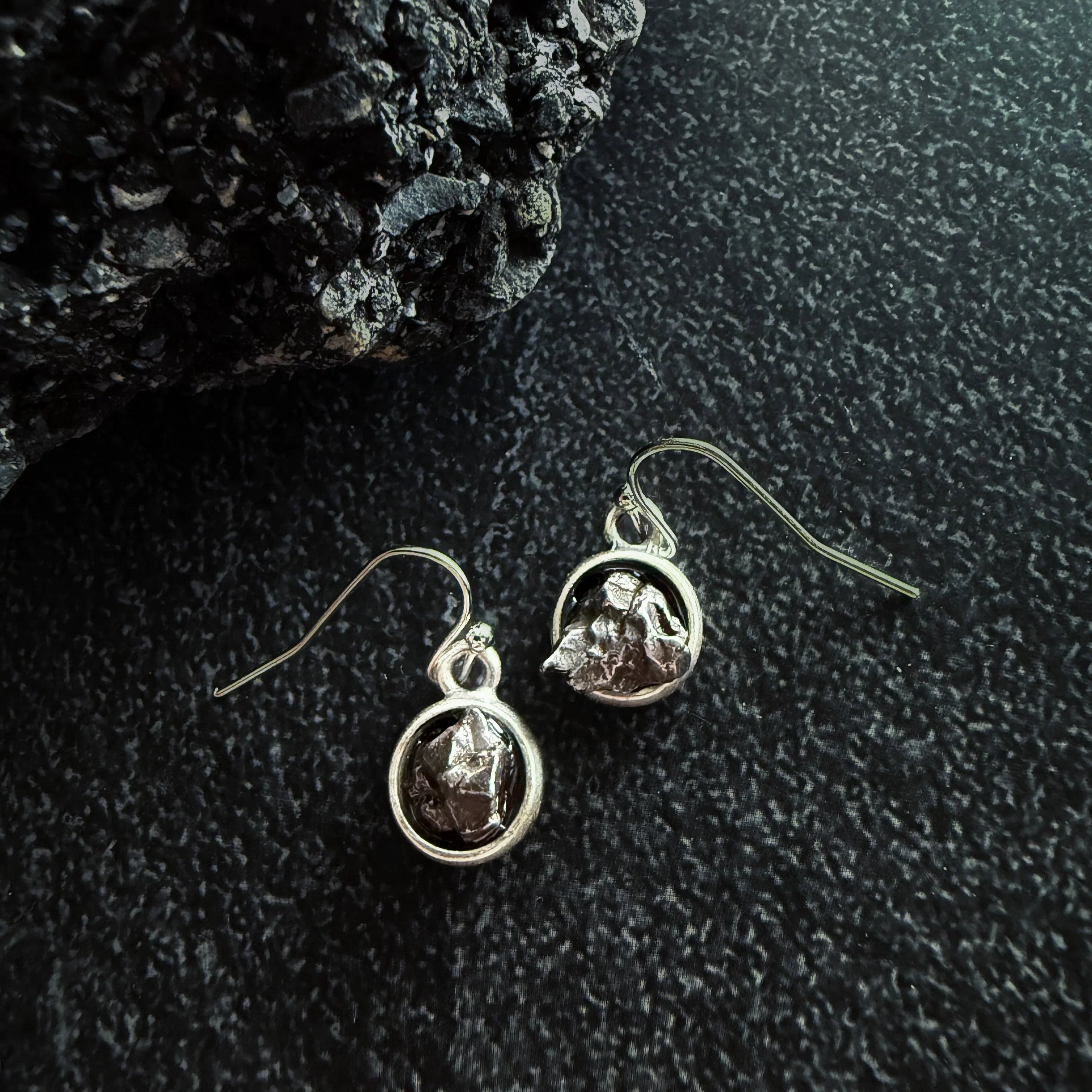 Silver dangle earrings with raw stone design on textured dark background, Qu!rk Boutique jewelry