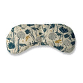Curved floral eye pillow with teal, mustard, and black botanical prints on a white fabric background