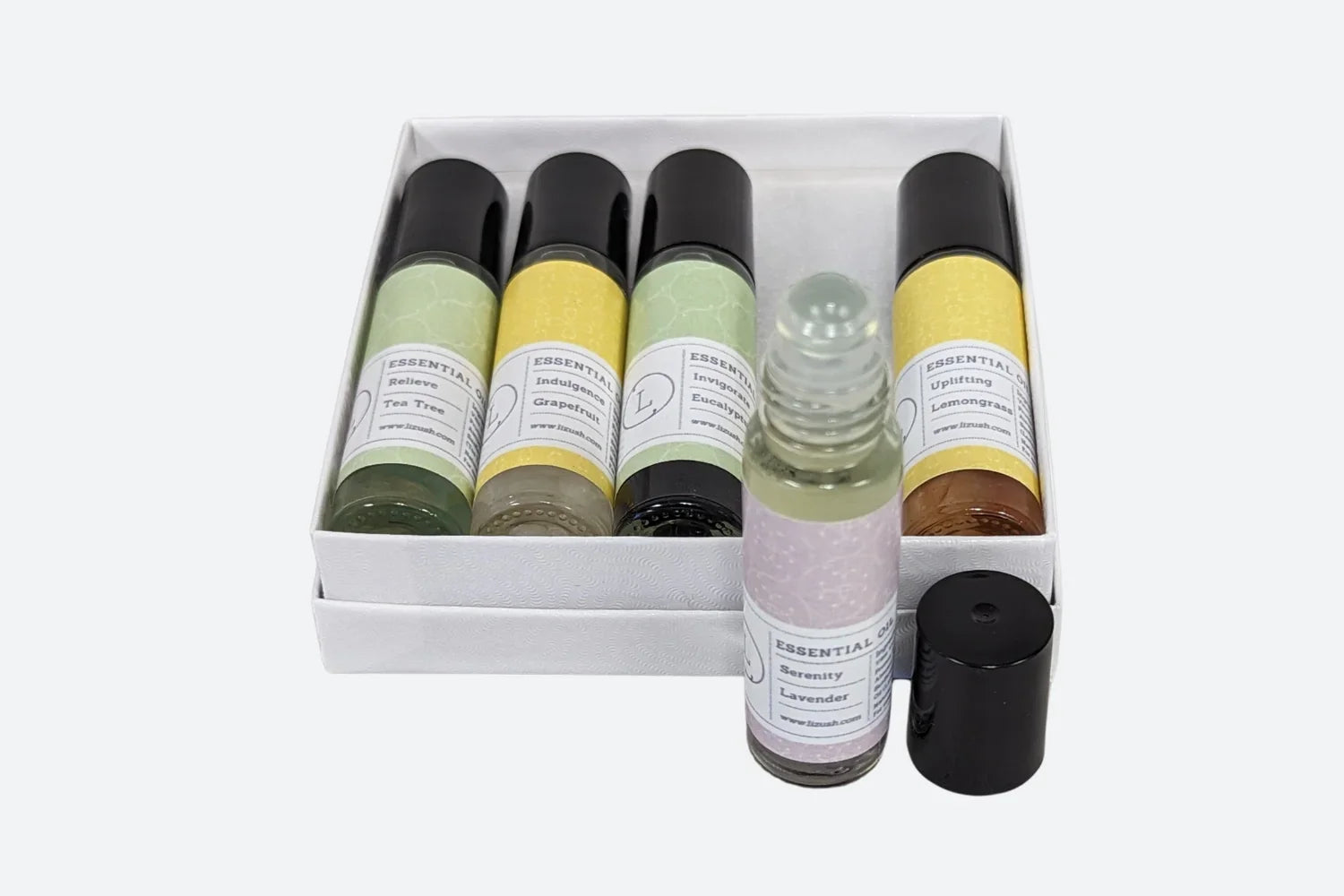 Set of five essential oil roller bottles with labels including Lavender, Tea Tree, Grapefruit, Eucalyptus, and Lemongrass