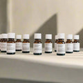 Essential oil diffuser blends in amber bottles, displayed on a light surface at Qu!rk Boutique.