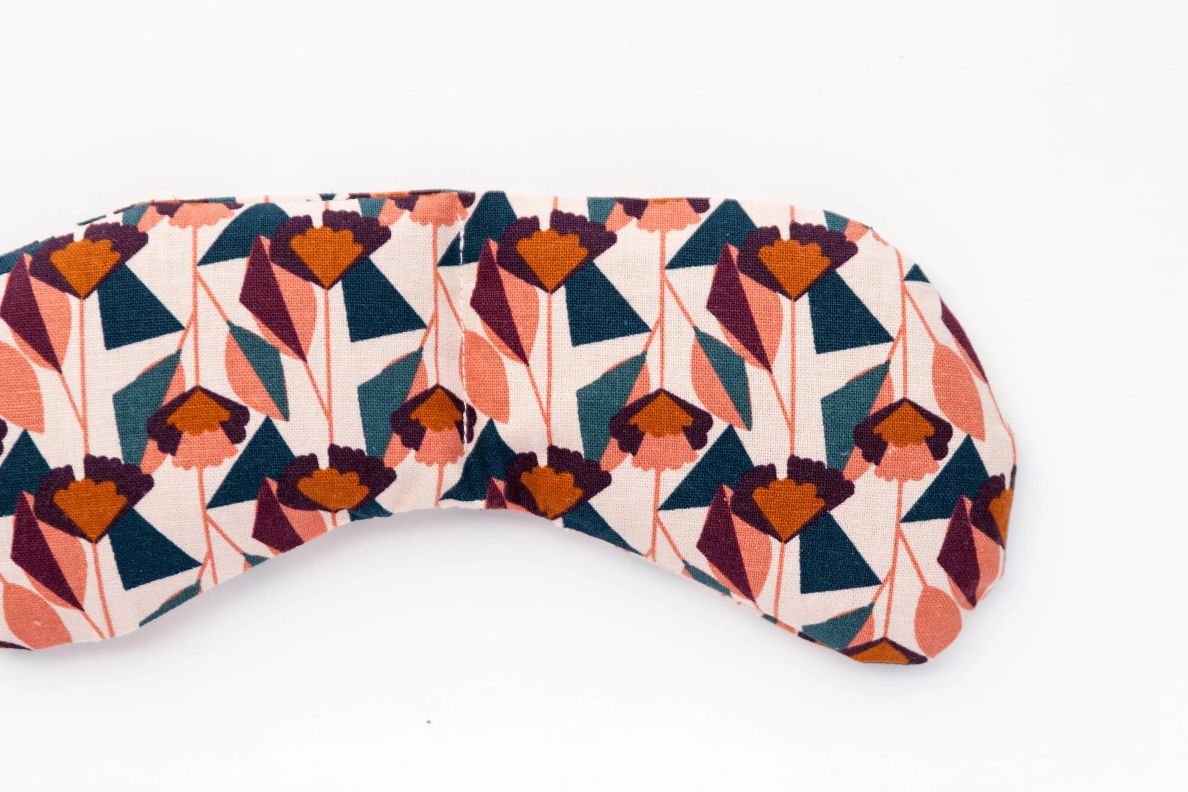 Floral patterned blush eye mask with geometric shapes on white background