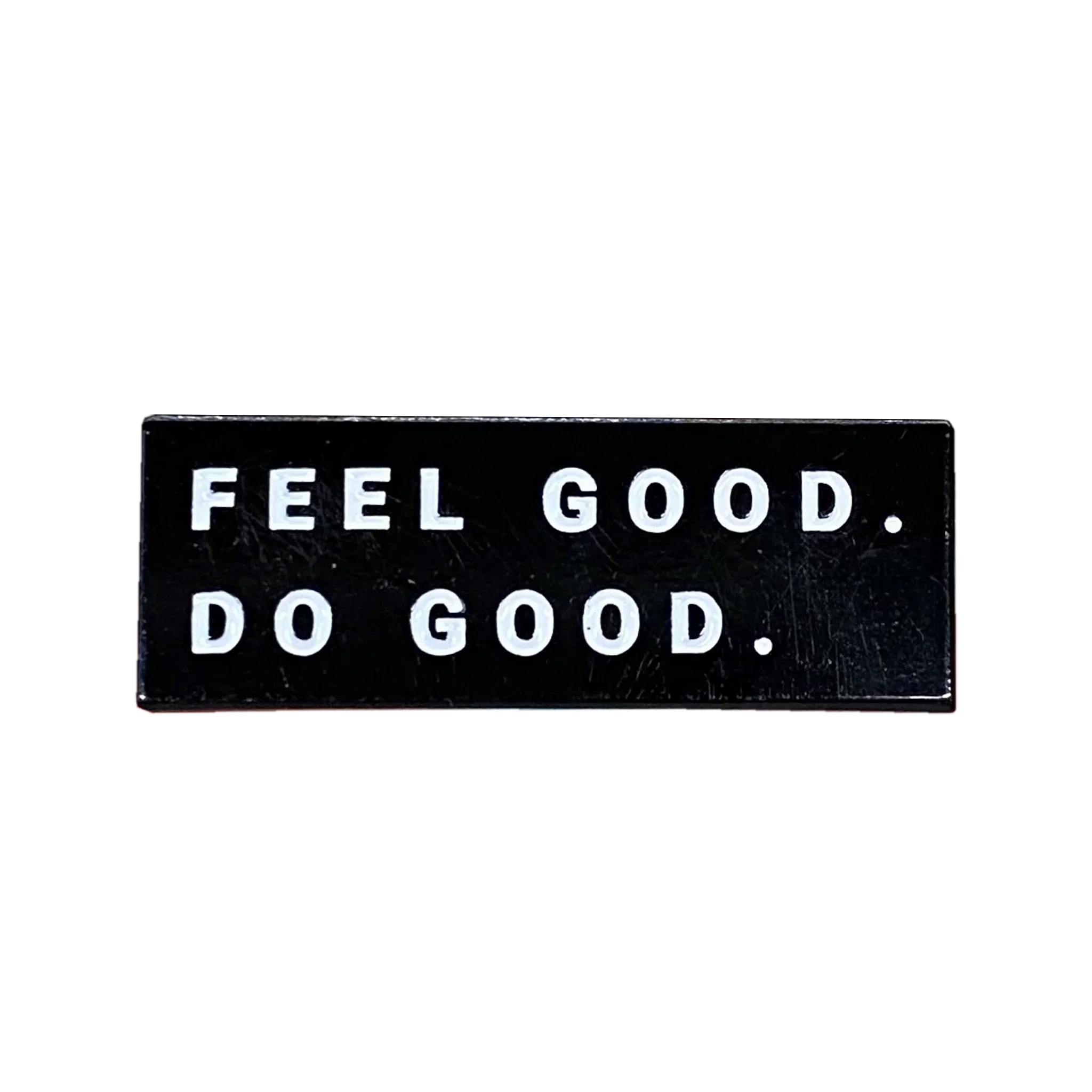 Black enamel pin with white text reading 'FEEL GOOD. DO GOOD.' from Qu!rk Boutique gift shop.