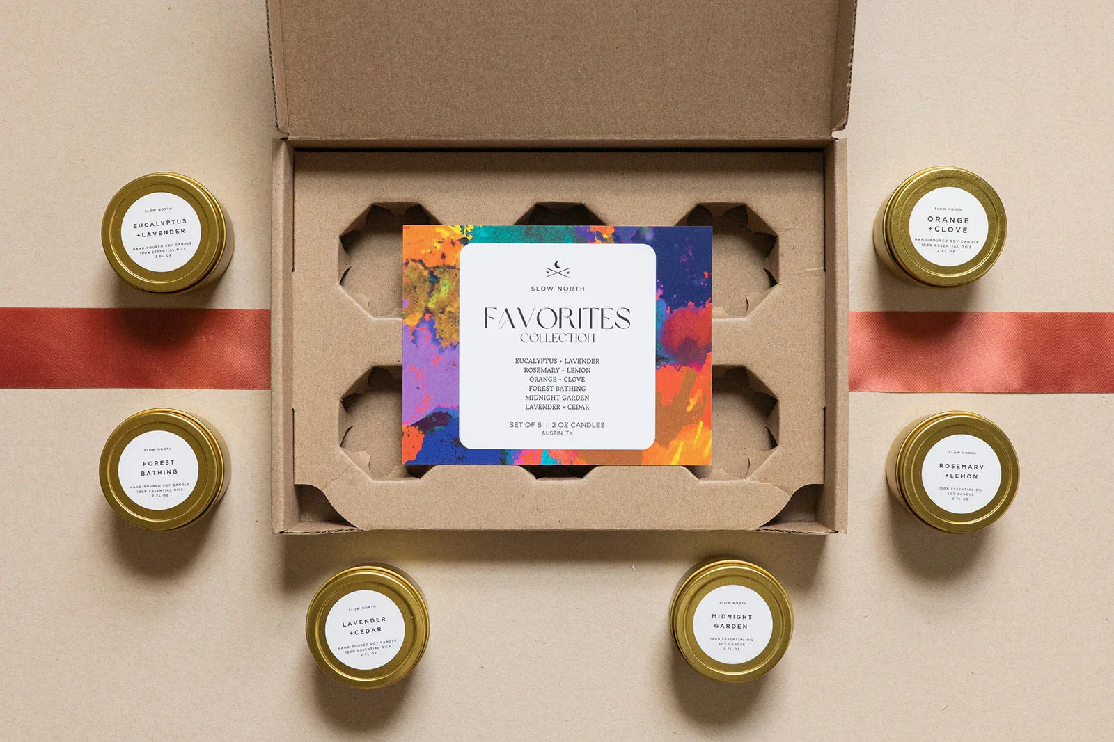 Set of six Slow North scented soy candles in gold tins with eucalyptus lavender, orange clove, and other fragrances